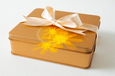 Sonbahar ortası festivali, beyaz arka planda saten kurdeleyle süslenmiş altın hediye kutusu.