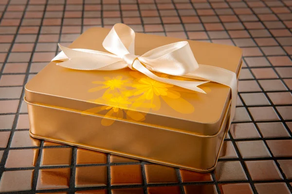 Gouden Geschenkdoos Gebonden Met Satijnen Lint Tegelachtergrond — Stockfoto