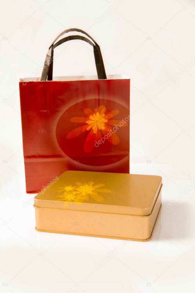 Golden gift box with red handbag on white background