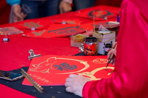 Chinese people sell their handwritten Spring Festival couplets during the Spring Festival