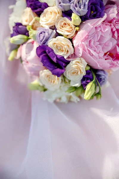 Pink bouquet of a bride from peonies and roses on a pink background