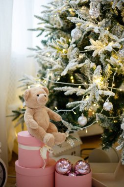 Sarı çelenklerle süslenmiş Noel ağacında oyuncak oyuncak ayı