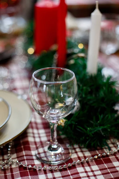 Склянка на різдвяному столі, прикрашена свічками і мішурою — стокове фото