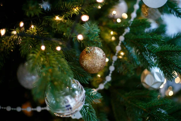 Yeşil Noel dalları beyaz ve altın topları, boncuk ve çelenk ile dekore