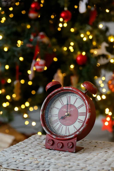Christmas toy clock on the background of yellow lights of the garland — Stock Photo, Image