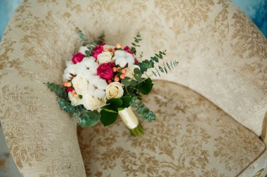 gül ve pamuk bir düğün buketi bir sandalyede yatıyor