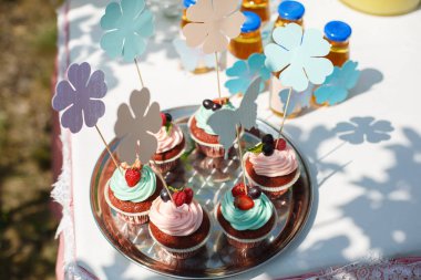 Krema, çilek ve kuş üzümü ile süslenmiş çikolatalı kekler