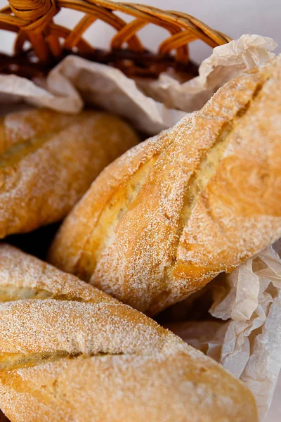 Tres baguettes frescos yacen en una canasta de mimbre — Foto de Stock