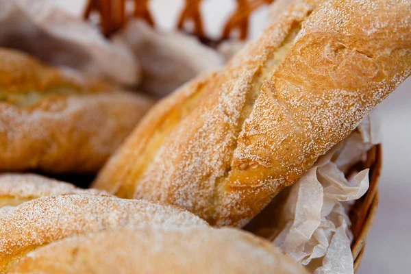 Tres baguettes frescos yacen en una canasta de mimbre — Foto de Stock