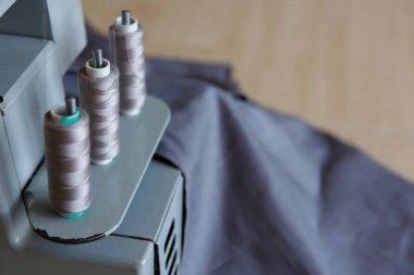 Natürmort. Dikiş malzemeleri. Overlok iplikler ve gri kumaş