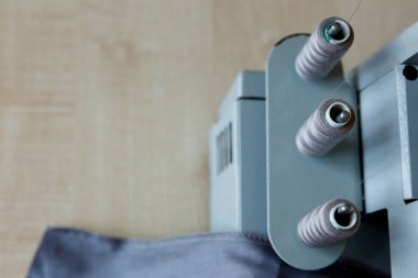 Natürmort. Dikiş malzemeleri. Overlok iplikler ve gri kumaş