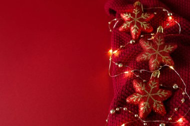 Noel oyuncakları, boncuklar ve örülmüş kumaş üzerinde bir çelenk..