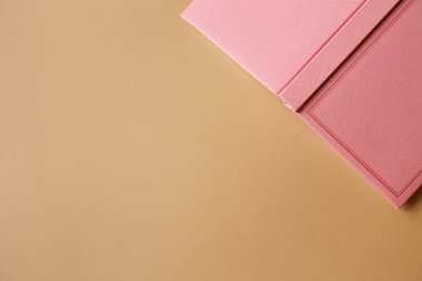 Pembe defter, günlük ya da kitabın kapağı kahverengi kağıttan arka planda düz yatıyordu