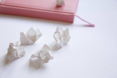 Beyaz arka planda pembe günlük ve buruşmuş kağıt parçaları. Mektuptaki hatalar