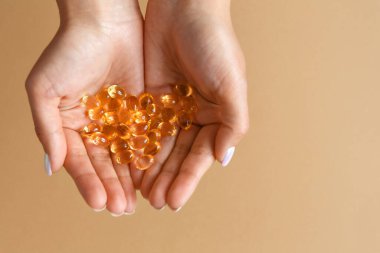 Kadın avuçlarında omega-3 vitamini kapsülü ya da tablet tutuyor. Sağlıklı beslenme ve yeme alışkanlığı..
