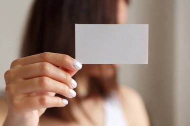 Elinde beyaz bir kartvizit tutan kadın, kapat. Metin için boş boşluk