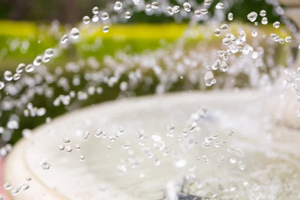 A stream of clear water with sparkling drops pours from the fountain tap. Ecology concept. Natural background. Natural resources of the planet