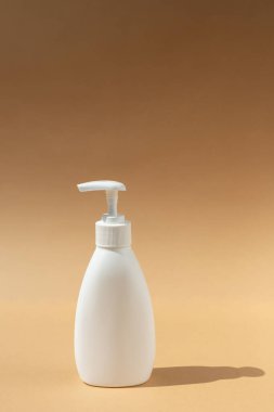 Beyaz şeker şişesi, bej ya da kahverengi arka plandaki kaplıca ürünleri için. Anti bakteriyel sabun. Metnin için yer.