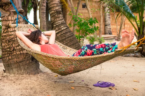 Młoda kobieta relaksująca się w hamaku na plaży podczas letnich wakacji — Zdjęcie stockowe