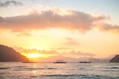 Gün batımında geleneksel filipinli tekneler, El Nido, Filipinler