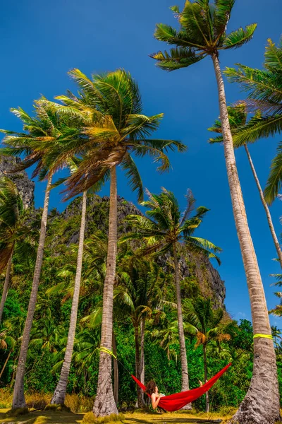 Kobieta relaksująca się w hamaku między palmami na wyspie, Palawan, Phillipines — Zdjęcie stockowe