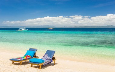 Plaj sandalyeleri, berrak su ve tropikal adada güzel görünümü,