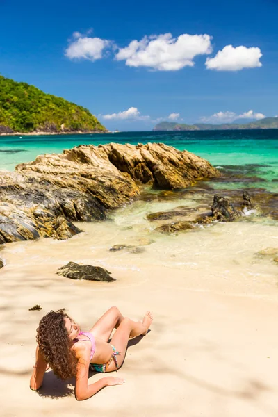 Młoda kobieta z kręconymi włosami opalająca się na egzotycznej wyspie — Zdjęcie stockowe