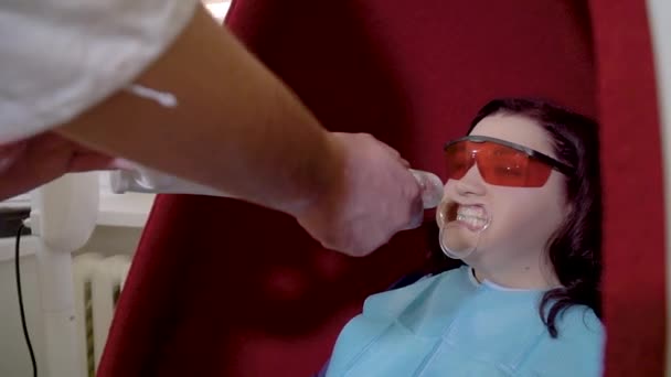 Dentista accende lampada UV al paziente per lo sbiancamento dei denti — Video Stock