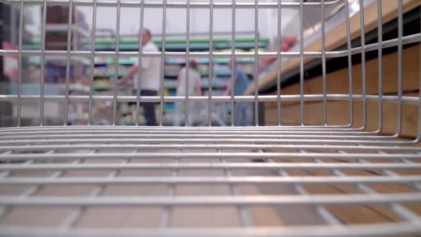 从食品店的空购物车看 人们在商店里买杂货的背景 — 图库视频影像