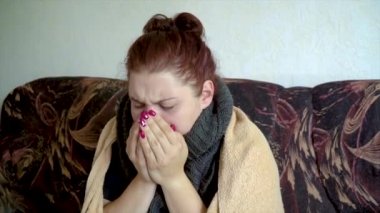yakın hasta Kafkas kız battaniye altında kanepede oturan ve öksürük