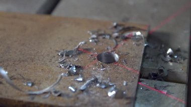El işçisi metal parçalarını işledikten sonra fırça darbelerini temizliyor