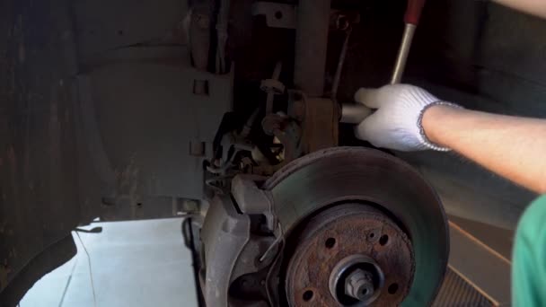 Mecánico desenrosca perno amortiguador coche — Vídeo de stock