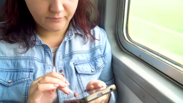 Молодая красивая кавказская девушка пользуется смартфоном в общественном транспорте во время поездки — стоковое видео