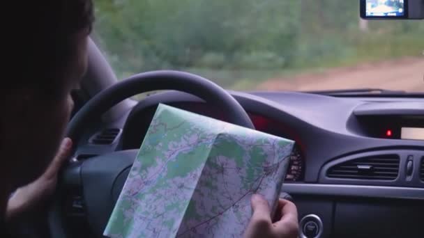 Uomo sta guidando una macchina, guardando la mappa su carta — Video Stock