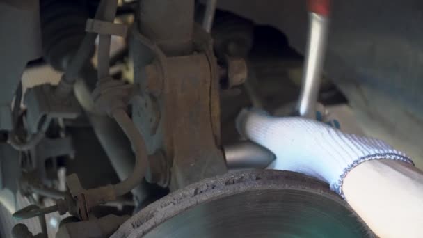 Close up mechanic unscrews bolt shock absorber car — Stock Video