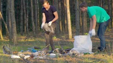 Gençler çöpleri ormanda paketler halinde toplar, çöpleri ormanda temizler, doğa bakımı konsepti