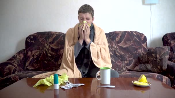 躺在毯子下的生病的高加索人坐在沙发上 在家里的纸巾上打喷嚏 发烧或流感的概念 — 图库视频影像