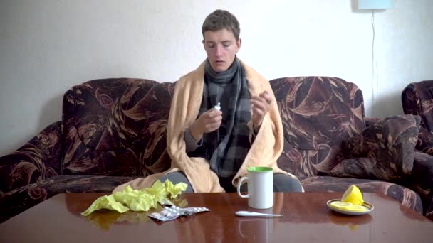 Homem Doente Caucasiano Senta Sofá Usa Spray Nasal Para Frio — Vídeo de Stock