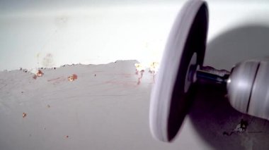 Tamirci araba tamir atölyesinde viski brite daireli matkap kullanarak araba gövdesindeki eski boya ve pasları öğütüyor. Araba tamircisi.