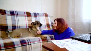 Kız, iş arasında evde köpekle oynuyor.