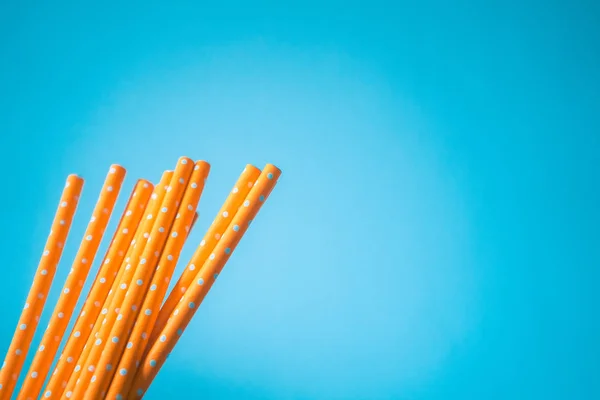 Yellow paper straws isolated on blue background