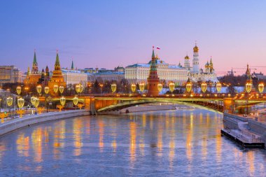 Moskova Kremlin manzaralı gece şehri manzarası ve nehir sularında yansımalar.