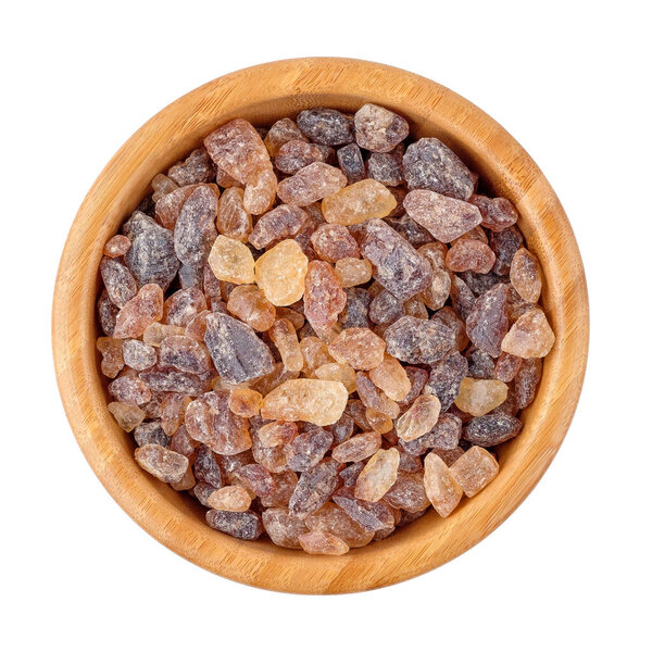 Candy sugar in a wooden bowl on white isolated background.