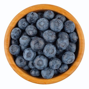 Beyaz arka planda izole edilmiş ahşap kasede olgun yabanmersini. Üst görünüm.