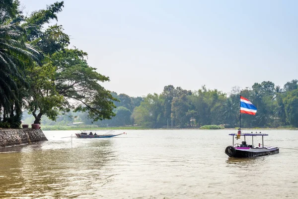 Khwae Yai Nehri üzerinde Tayland bayrağı taşıyan tekne.