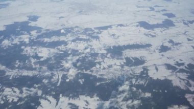 Karlı kış tarlaları ve bulutlar üzerinde uçaktan havadan görünüm