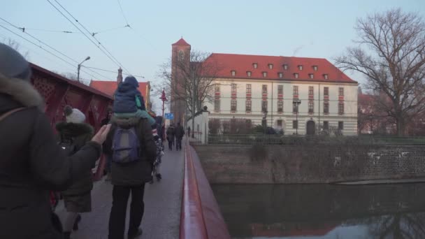 Pessoas se reúnem na ponte vermelha que leva a Ostrow Tumski em Wroclaw — Vídeo de Stock