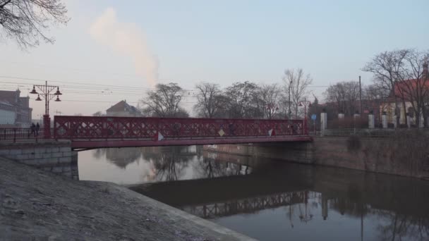 Blauer Zug und Menschen auf der roten Brücke, die zum Ostrow Tumski führt — Stockvideo