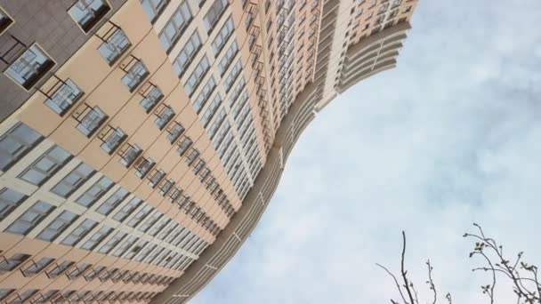 Titta uppsyn på krökt ny byggnad fasad och blå molnigt himmel — Stockvideo