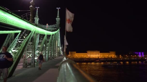 As pessoas caminham na Liberty Bridge iluminada à noite — Vídeo de Stock